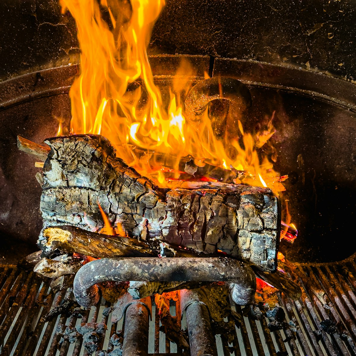NatureStove Grill Grate Pro placed over a fire pit for outdoor cooking