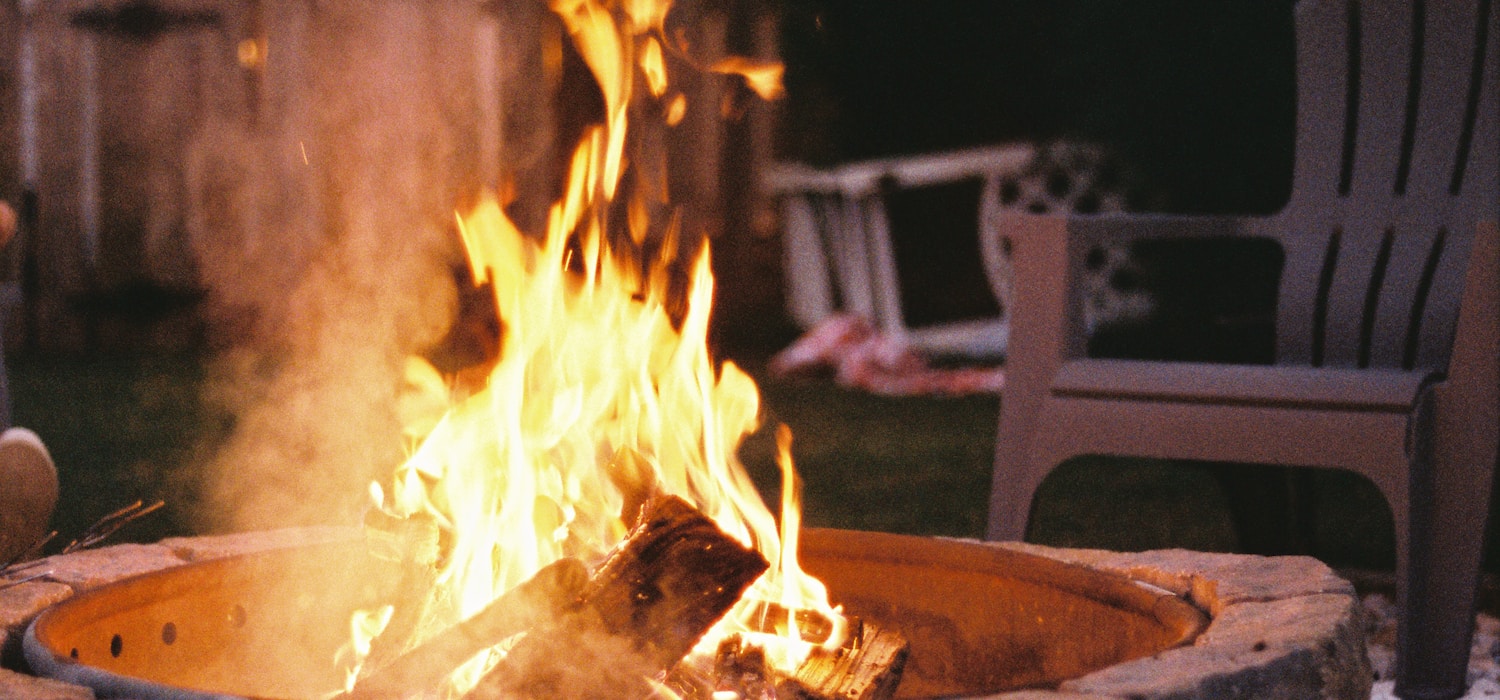 Wide shot of a fire pit outdoors at dusk